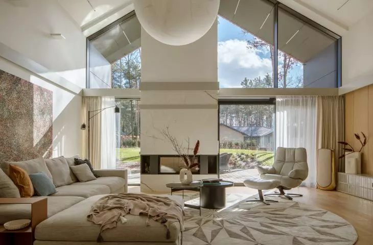 In Chotomow, near Warsaw, where a pine forest literally envelops the house, interiors permeated with tranquility and natural light were created