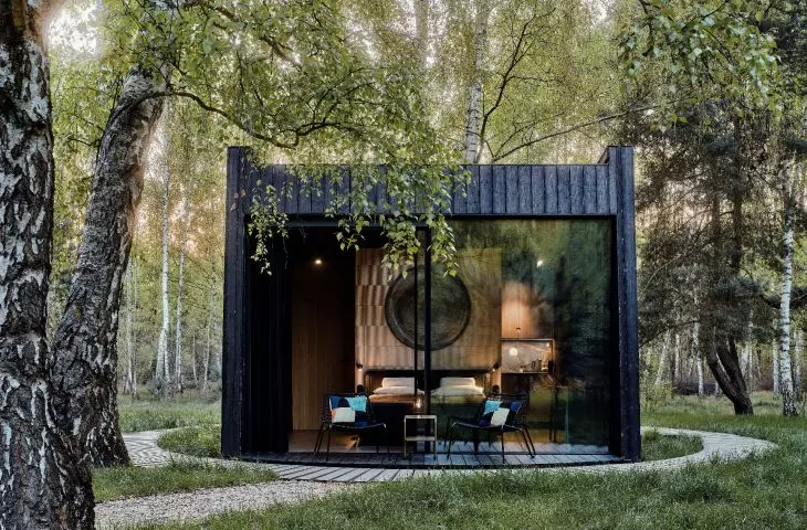 three of the facades of the cottage are covered with spruce planks, the fourth is completely glazed