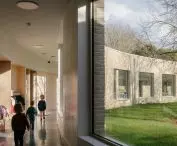 large windows not only illuminate the kindergarten corridor, but also frame the view of the inner courtyard