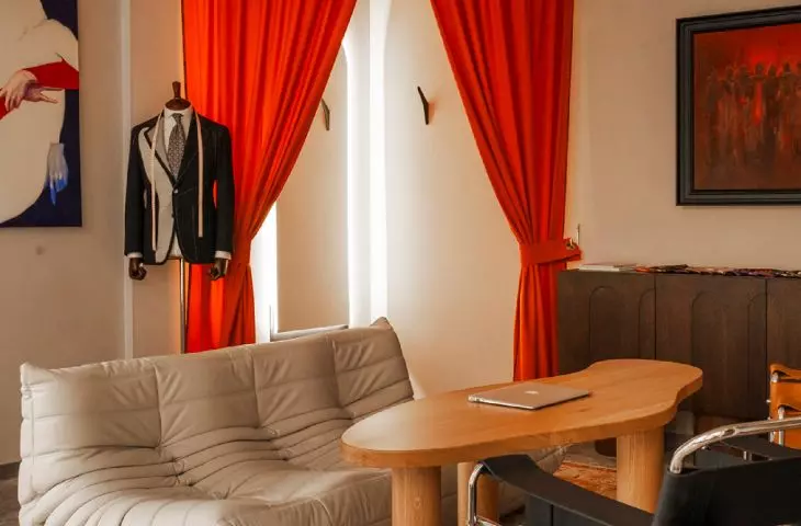 A fitting room hidden behind a red theatrical curtain