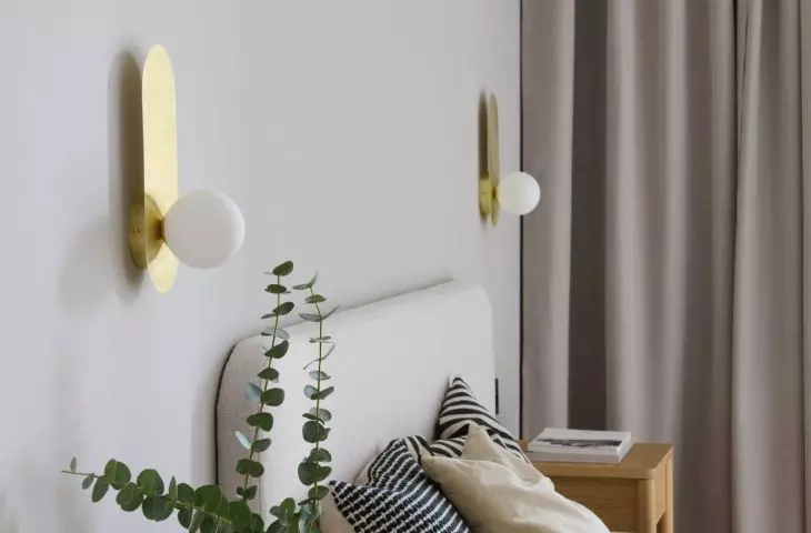 The bedroom is dominated by shades of beige, juxtaposed with wooden furniture and an upholstered bed 