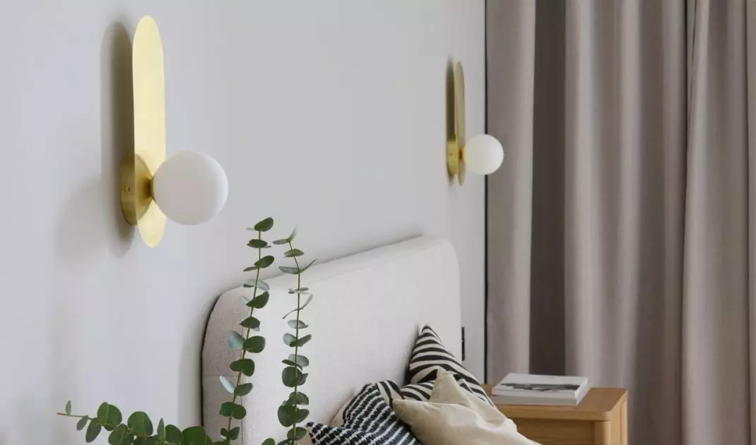 The bedroom is dominated by shades of beige, juxtaposed with wooden furniture and an upholstered bed 