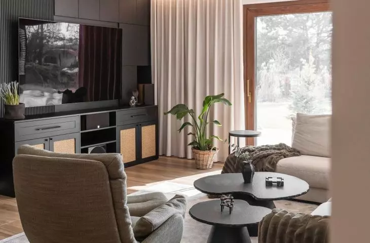 The living room has a large window with views of the surrounding nature 
