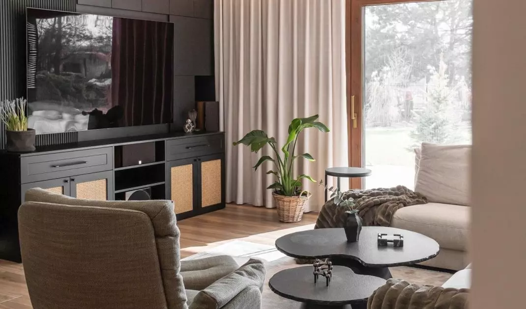 The living room has a large window with views of the surrounding nature 
