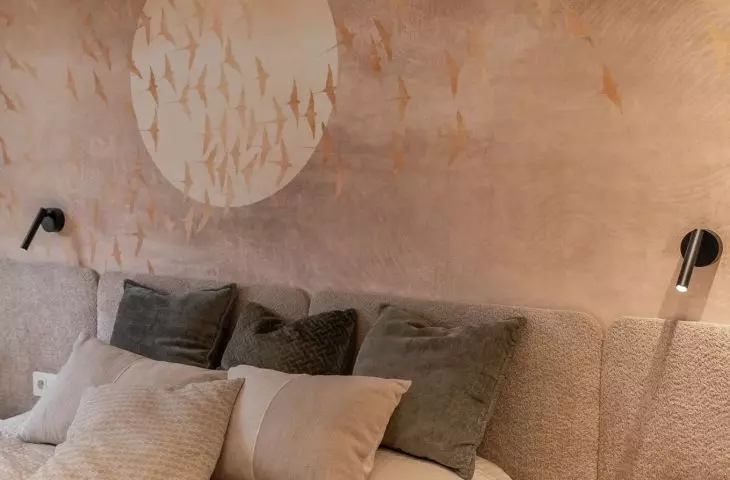 In the bedroom behind the bed there is wallpaper 