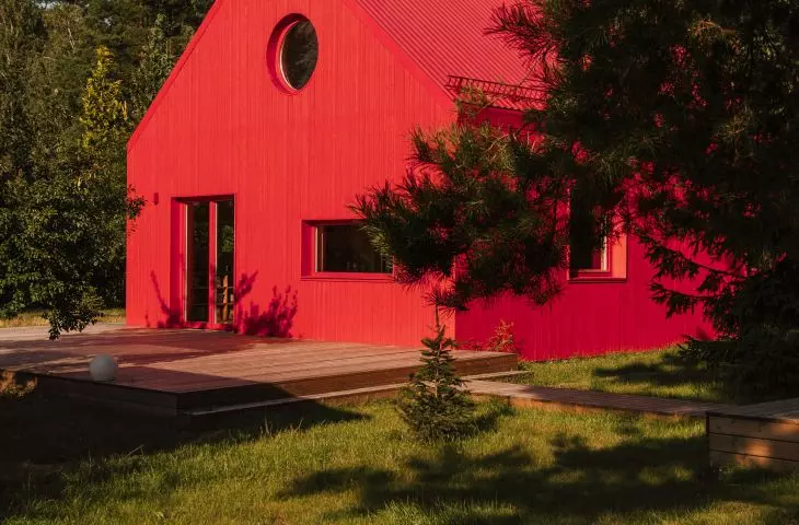 archetypal wooden house stands out for its juicy facade and roof color