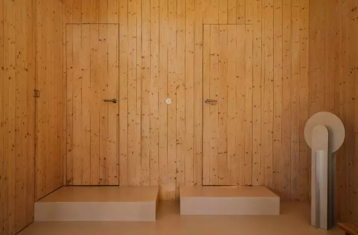 The bedrooms are on an elevated level, and the step leading up to them serves as additional seating 