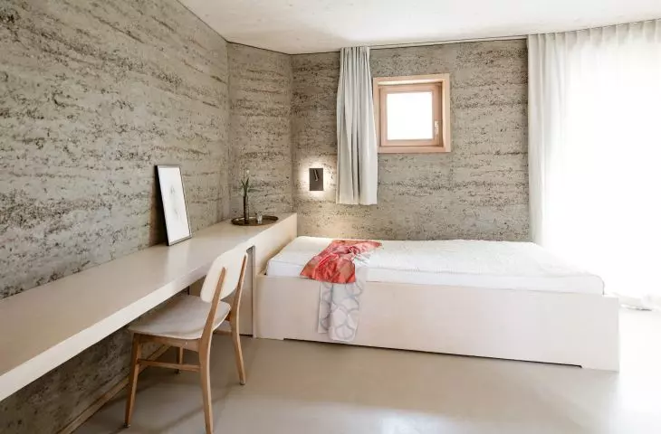 an example of a building located in Europe that was built according to sustainable design principles - using local natural materials, with the participation of local artists and contractors