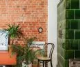 Green tiled stove harmonizes with red brick wall