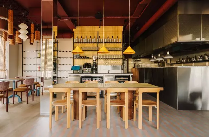 The yellow mosaic contrasts with the brushed steel, which the team used in both the kitchen and bar area