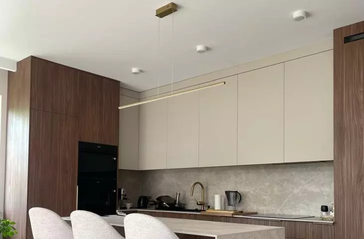 Modern LED Led Line lamp in gold over the kitchen island in an elegant interior