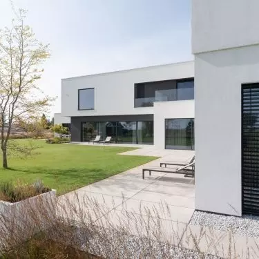 The multigenerational house is characterized by a cuboidal minimalist body with clearly defined functional zones.