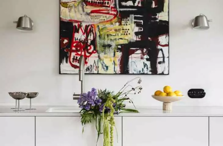 An abstract painting hangs in the kitchen 