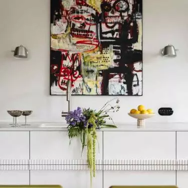 An abstract painting hangs in the kitchen 