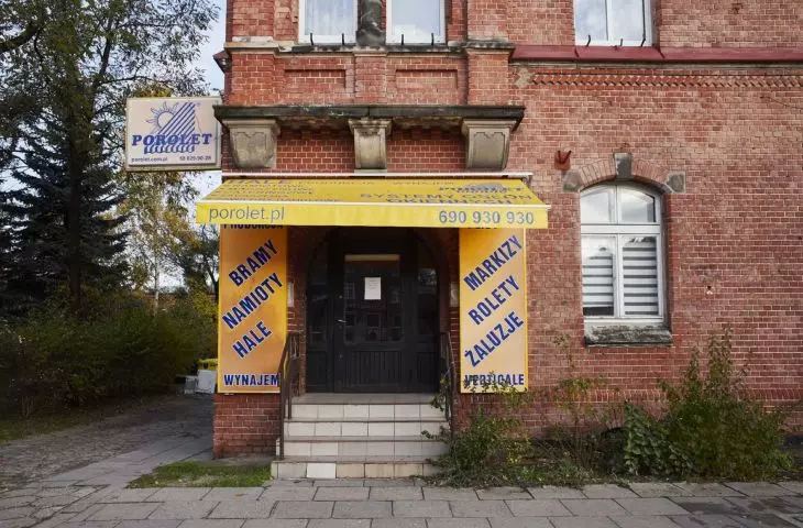 Yellow color, overwhelming awning and banners advertising office on Grunwaldzka Avenue