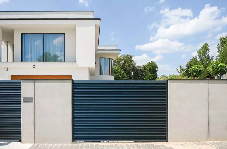 Ogrodzenie frontowe, wykonane z betonu architektonicznego z przęsłami typu żaluzja – z ocynkowanej stali, malowanej proszkowo