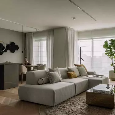 The heart of the apartment is the open living area, in which the living room, kitchen and dining room function as equal parts of a single composition