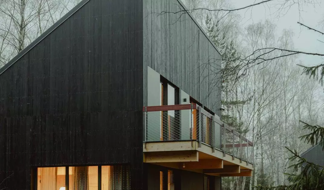 The facades of the buildings were made of black wooden planks, which were juxtaposed with color accents - yellow, maroon and dark green