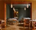 Corrugated sheet metal covered with soft fabric adorns restaurant walls
