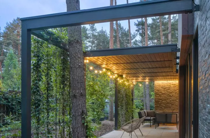The terraces are surrounded by vertical shielding bars referring to the trunks of pine trees giving a feeling of privacy thanks to the greenery wrapping around them