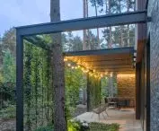 The terraces are surrounded by vertical shielding bars referring to the trunks of pine trees giving a feeling of privacy thanks to the greenery wrapping around them