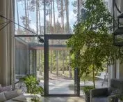 Two-storey living area with large glazing framing views of the forest