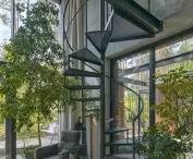 A spiral staircase leads to the mezzanine where the office space is located