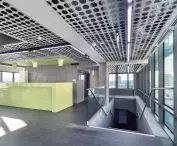 Surowe, industrialne wnętrza stref wejściowych do strzelnic uzupełniać mogą metalowe sufity z siatki, panele z perforacją czy wiszące wyspy sufitowe, fot. Szymon Polański dla Knauf Ceiling Solutions