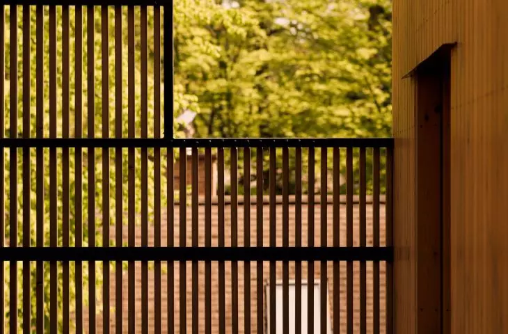 Here and there, the wooden facade has gaps, and the openwork screens allow light to reach the hidden terraces