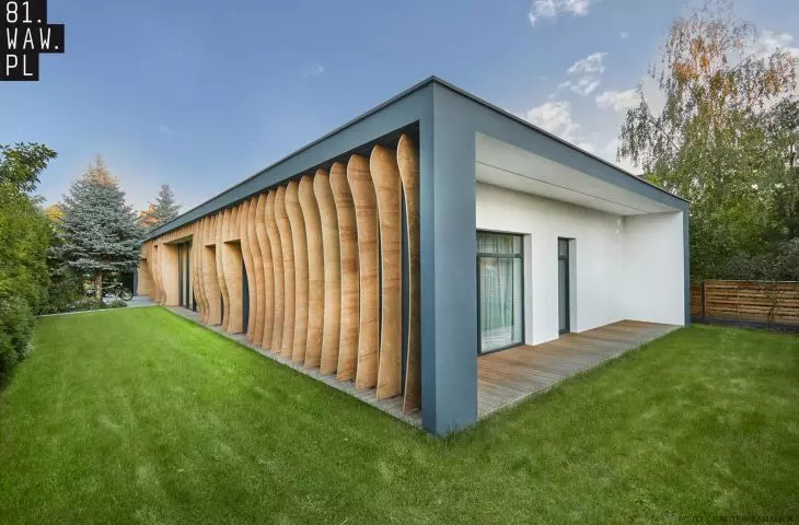 low, one-storey single-family house with a cuboidal body is diversified by wooden razor blades