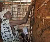 an elderly woman participating in the construction of the planned temporary shelter