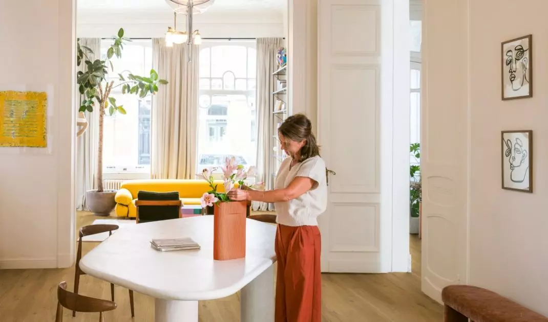 A soft, quilted sofa, light-colored flooring, and graphic accessories demonstrate how textures can create a retro vibe in an interior without resorting to literal styling