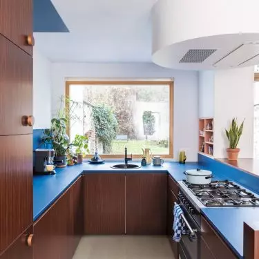 Color doesn't have to dominate the entire design: sometimes all it takes is a blue countertop paired with natural wood to give the kitchen some character