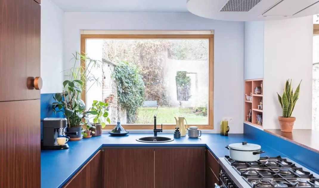 Color doesn't have to dominate the entire design: sometimes all it takes is a blue countertop paired with natural wood to give the kitchen some character