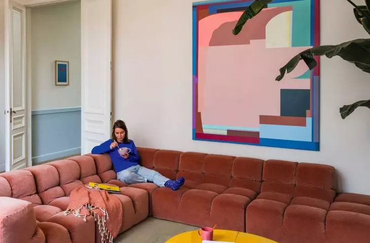 A soft, quilted sofa, light-colored flooring, and graphic accessories demonstrate how textures can create a retro vibe in an interior without resorting to overt styling