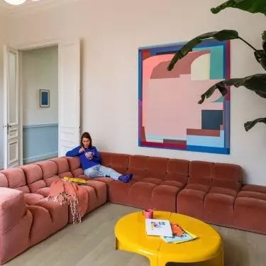 Miękka, pikowana sofa, jasna podłoga i graficzne dodatki pokazują, jak faktury budują we wnętrzu klimat retro bez dosłownej stylizacji