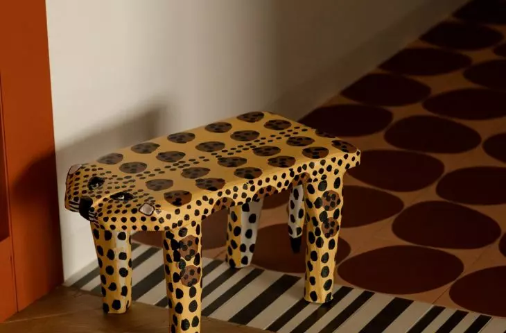 The colorful floor and the spotted stool set the tone for the apartment right from the very first steps