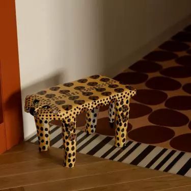 The colorful floor and the spotted stool set the tone for the apartment right from the very first steps