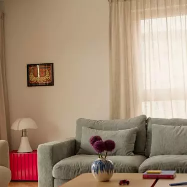The living room remains bright and cozy, but thanks to its colorful details, it doesn't lose any of its energy