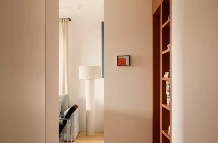The hallway serves as a colorful introduction to the apartment—with a striking floor and a spotted stool 