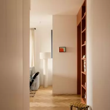 The hallway serves as a colorful introduction to the apartment—with a striking floor and a spotted stool 