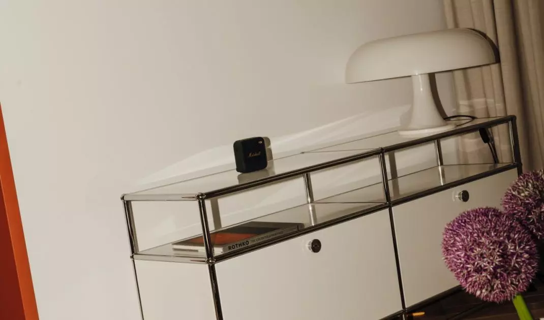 Chromowana komoda i miękkie światło wprowadzają do salonu spokojniejszy, bardziej elegancki ton