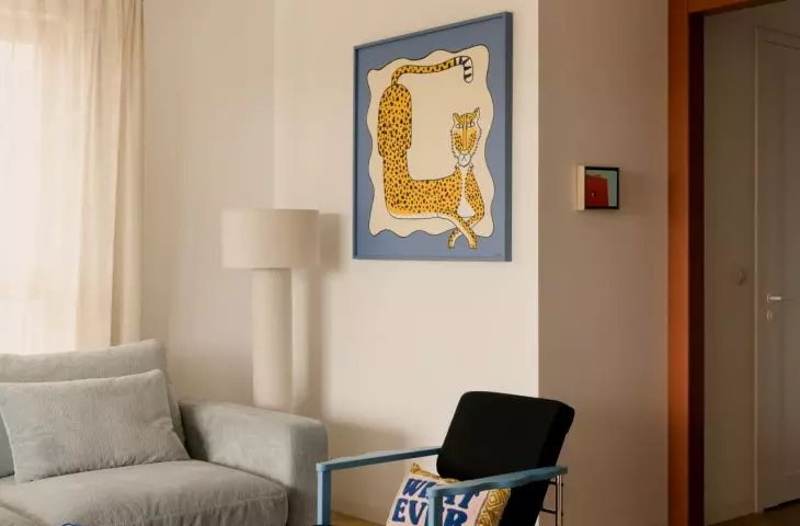 The blue, the spots, and the graphic rug break up the living room’s neutral base, giving it a more relaxed feel