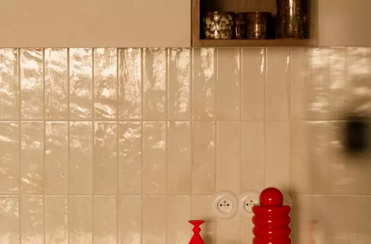 Colorful accents liven up the kitchen's neutral color scheme and highlight the interior's retro character 