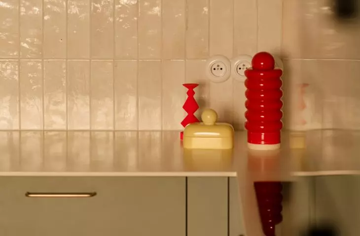 Colorful accents liven up the kitchen's neutral color scheme and highlight the interior's retro character
