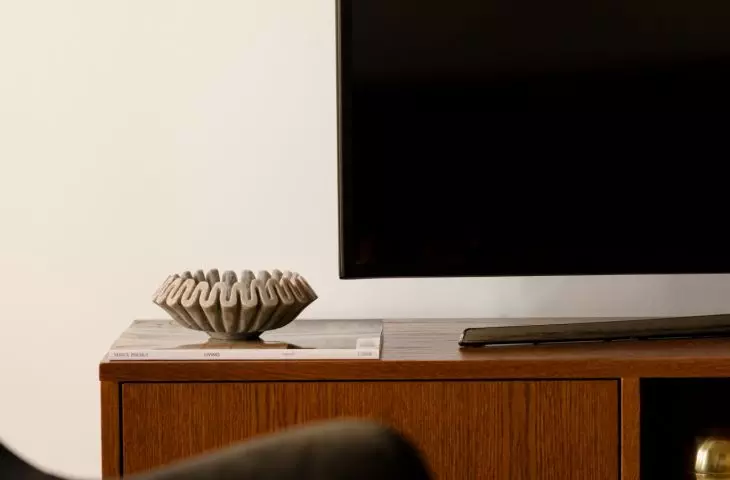 A wooden TV cabinet adds warmth to the living room and brings a mid-century vibe to the space