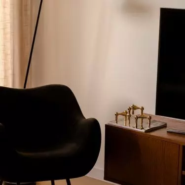A wooden TV cabinet adds warmth to the living room and brings a mid-century vibe to the space
