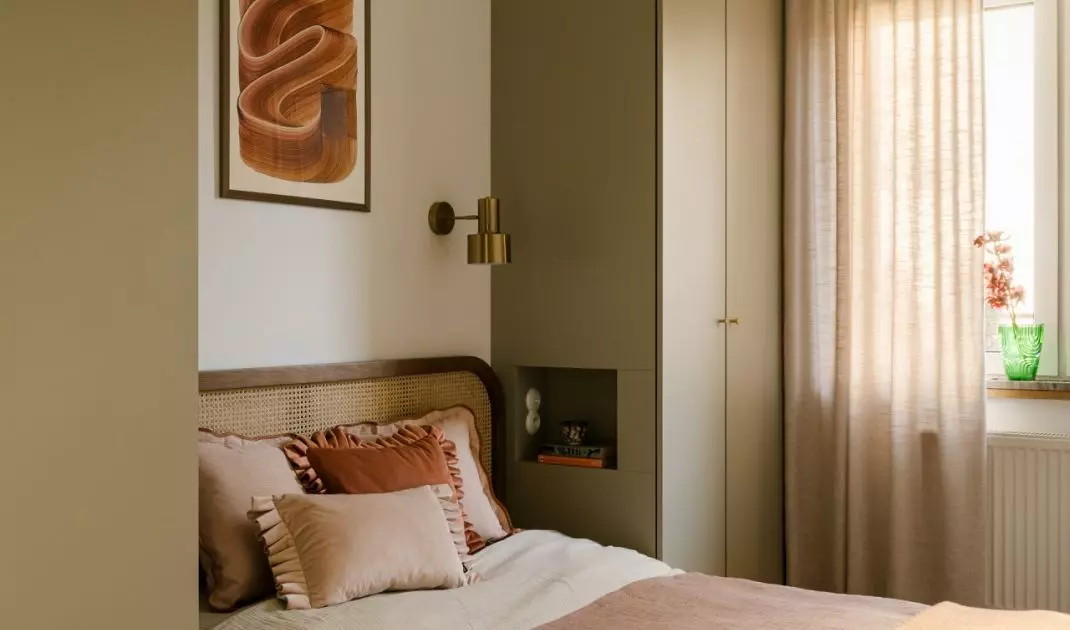 Soft textiles, a woven headboard, and a rust-colored throw create an intimate atmosphere in the bedroom