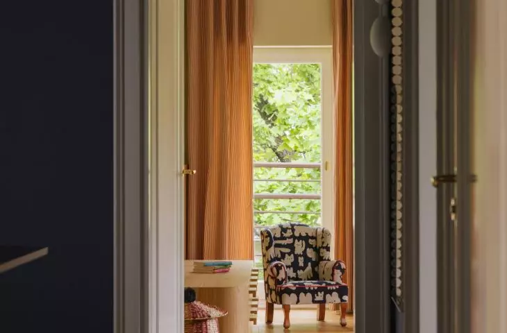 A dark hallway leads to the children's room, where light, color, and patterns instantly transform the atmosphere of the apartment