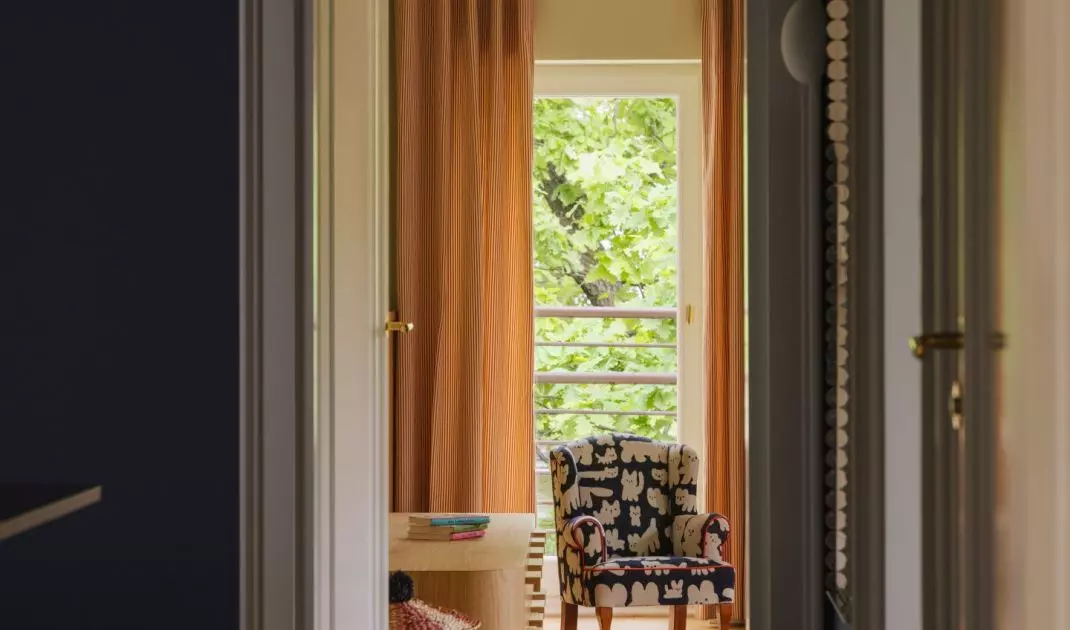 A dark hallway leads to the children's room, where light, color, and patterns instantly transform the atmosphere of the apartment
